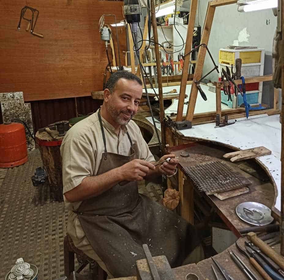Artisan bijoutier marocain à Tiznit forgeant un bijou en argent